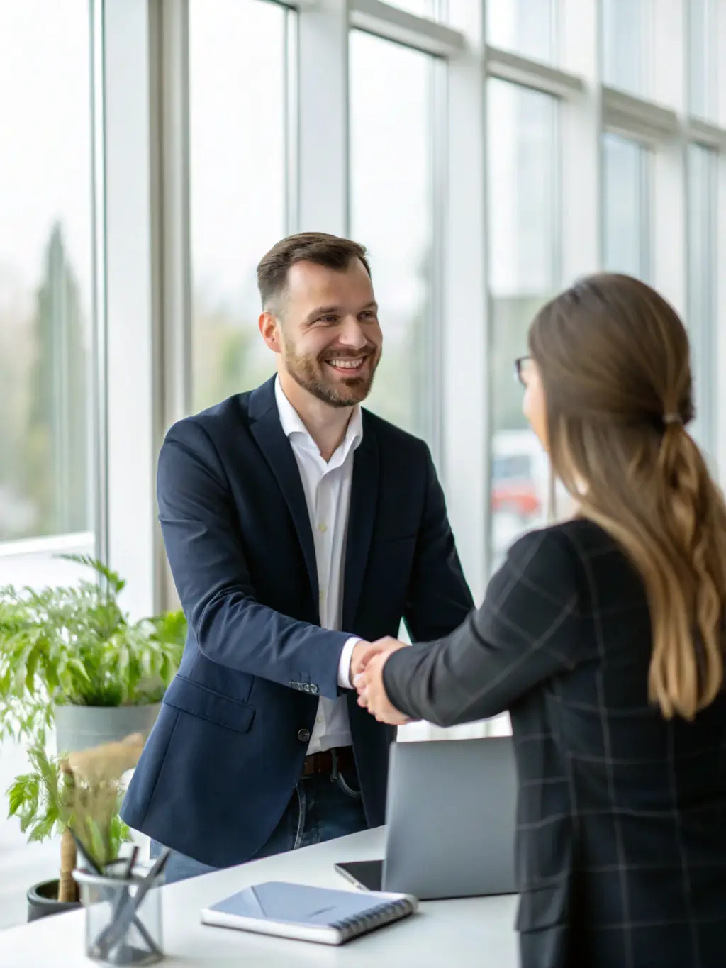 A satisfied client shaking hands with a Netexpress consultant in a modern office setting, representing the company's commitment to client satisfaction.
